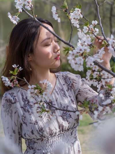 身穿黑白花裙手持白花的女子